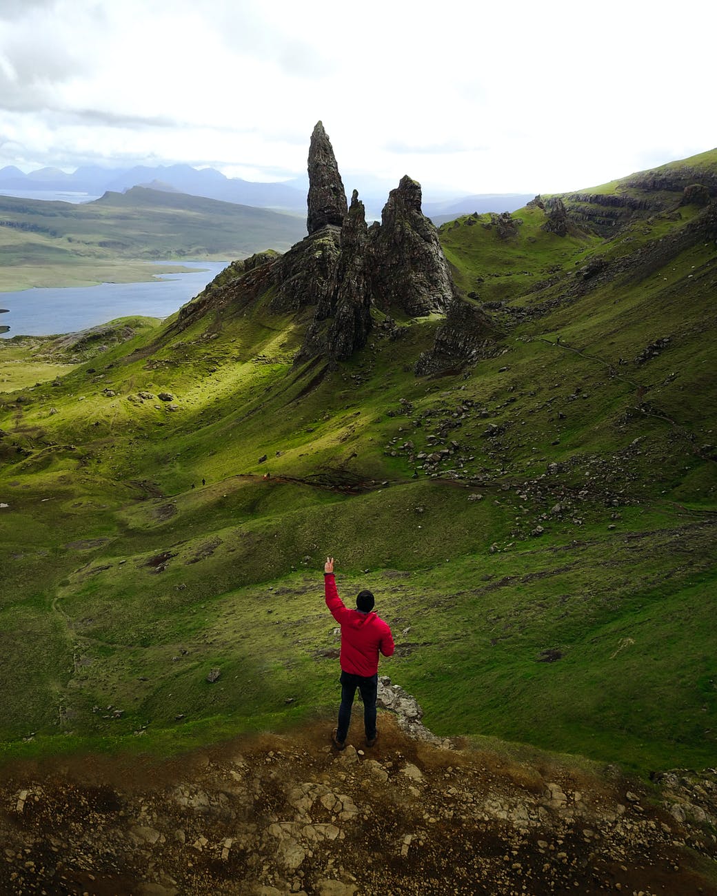 man wearing red jacket doing peace sign