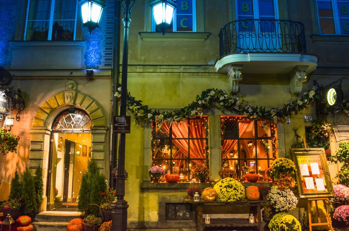 assorted flowers beside brown concrete house a nighttime