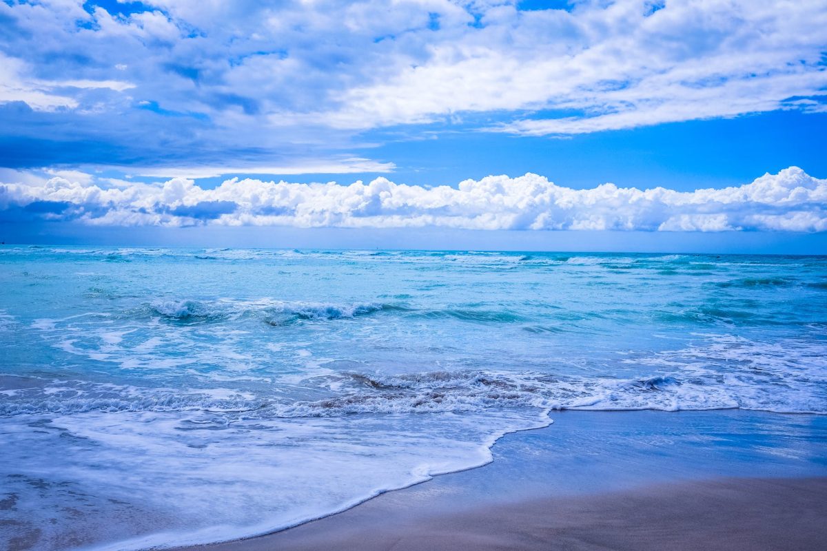 body of water under blue and white skies